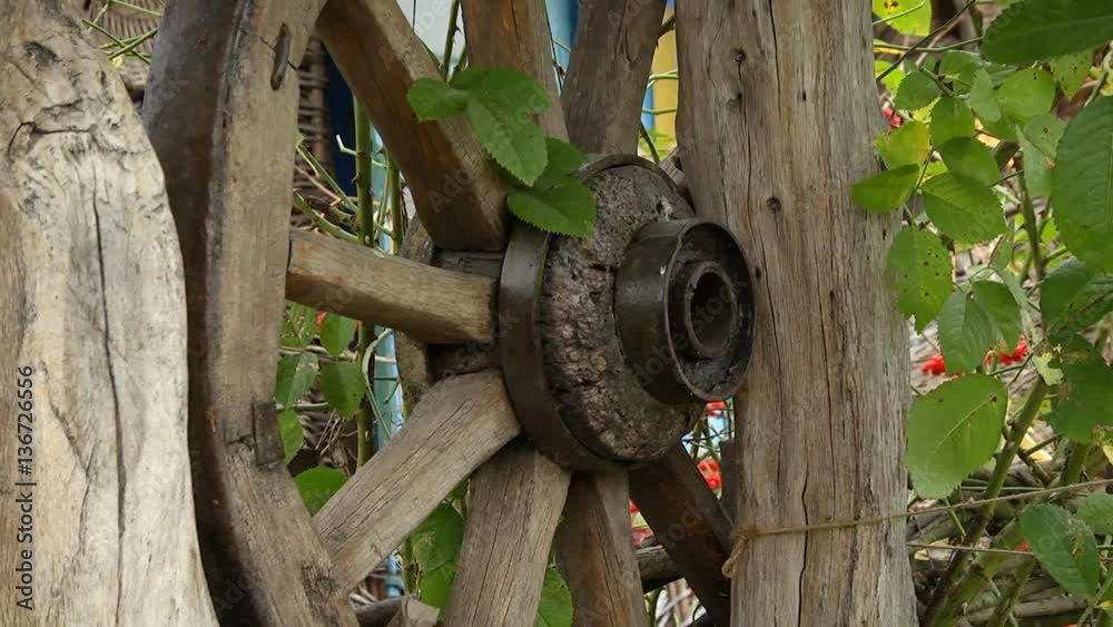 Old Wooden Wheel as a Decoration Old wooden wheel as decoration in the garden in the countryside of ancient manor Old Wooden Wheel as a Decoration Old wooden wheel as decoration in the garden in the countryside of ancient manor