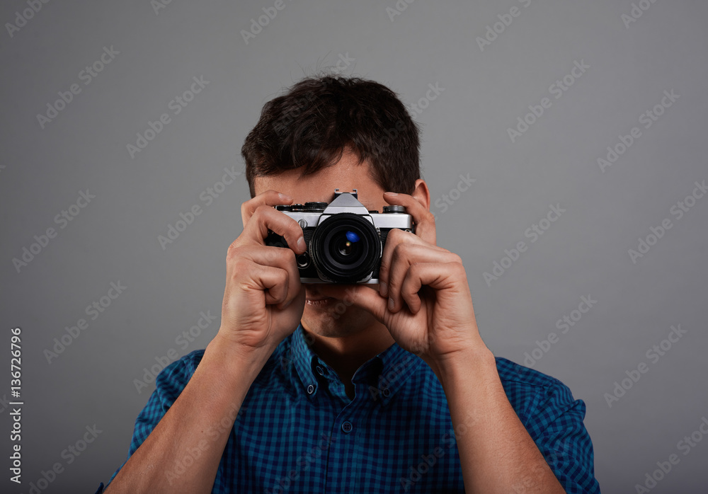 Close up high detailed portrait of tourist who making photo with vintage camera. Handsome man portrait in studio. Touristic concept on neutral grey background. Close up high detailed portrait of tourist who making photo with vintage camera. Handsome man portrait in studio. Touristic concept on neutral grey background.