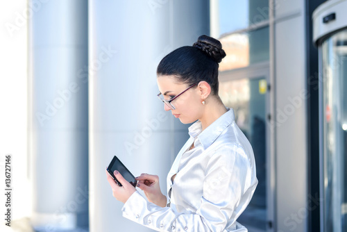 Portrait of a business woman businesswoman in glasses holding a tablet. The concept of leadership and success.
