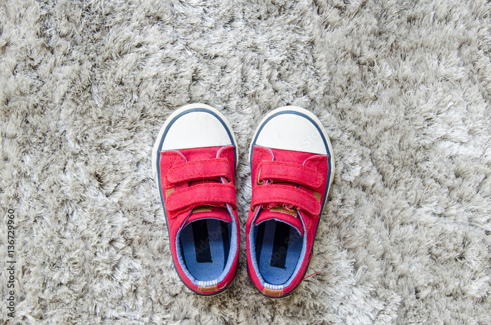 Fototapeta premium Red kid sneaker on gray mat.
