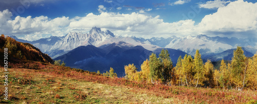 Autumn landscape and snowy mountain peaks.