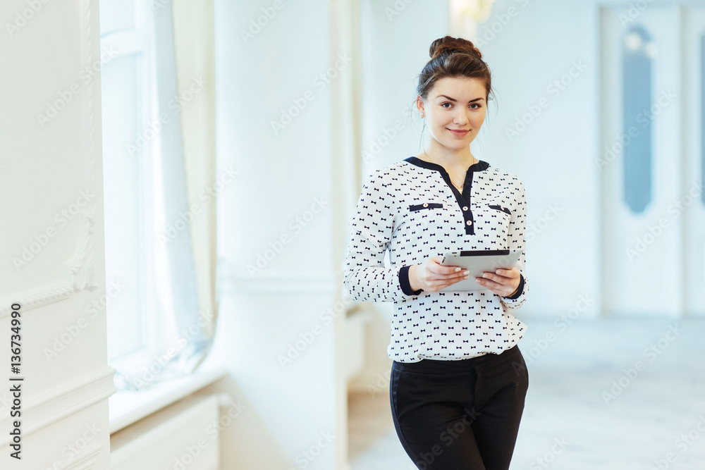 Smiling business woman holding a tablet computer at the office