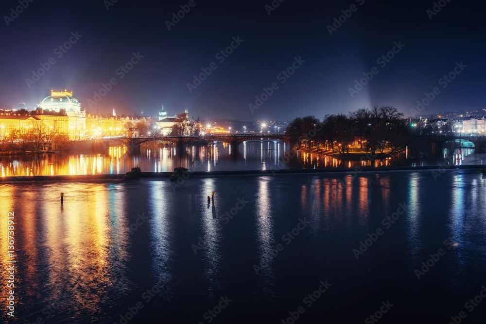Reflection of Prague caste and the Charles bridge at dusk.