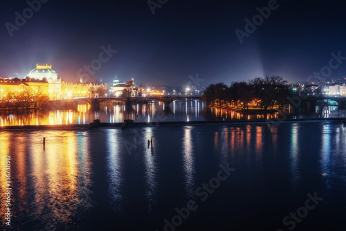 Reflection of Prague caste and the Charles bridge at dusk.