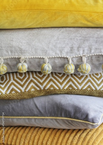 Pile of grey and yellow cushions , interior colour scheme
