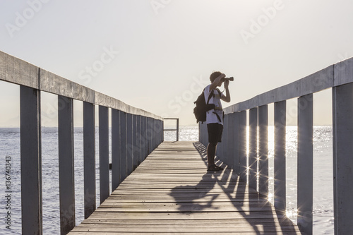 Brazil, State of Rio de Janeiro, Paqueta Island, Photographer on wooden dock during the sunset photo