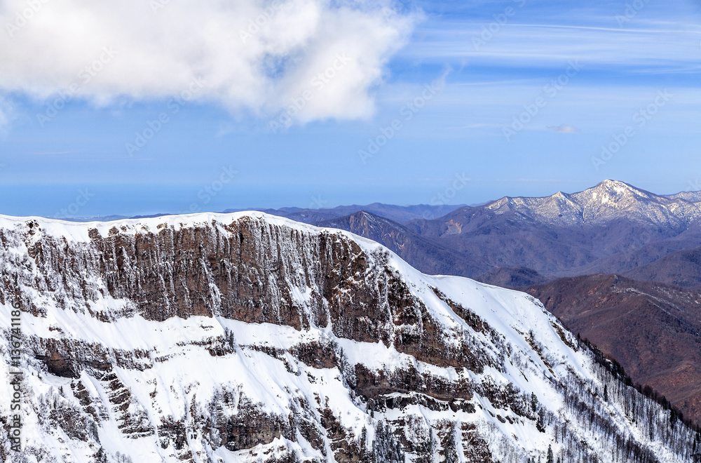 Beautiful scenic mountain winter landscape with snowy peaks and blue sky. Sochi, Russia