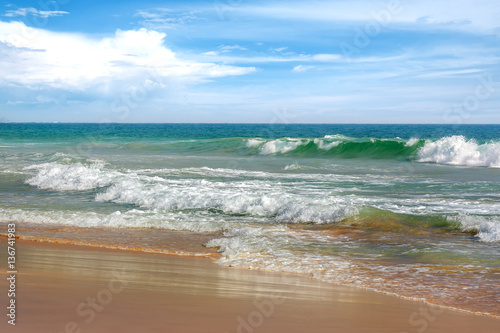 Sandy beach and turquoise ocean waves.