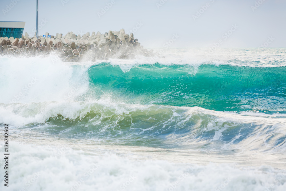 Fototapeta premium Blue wave in ocean. Ocean swell. Sea and city