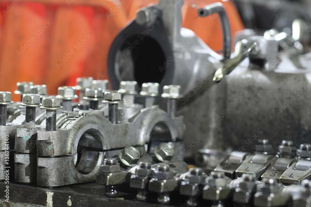 Parts of a disassembled car engine organised on the table for the period of repair Parts of a disassembled car engine organised on the table for the period of repair