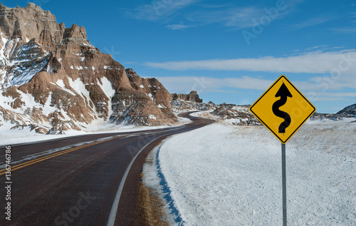Canvas Print Sharp Curves Warning Sign:  A sign warns of a twisting road ahead on a winter day in Badlands National Park