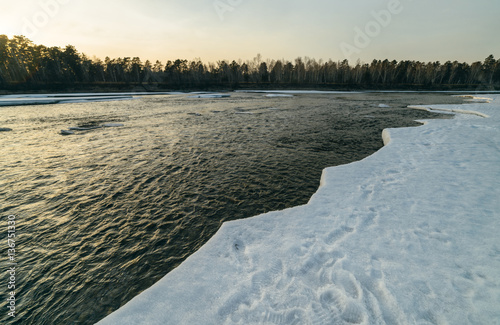 Winter sunset in river.