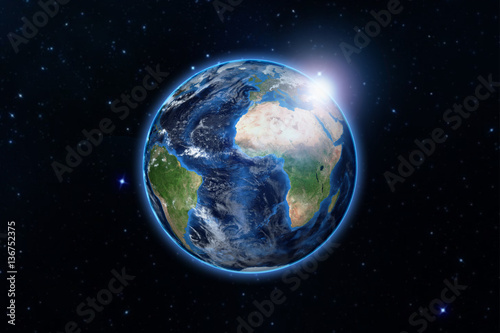 Fototapeta Naklejka Na Ścianę i Meble -  blue planet earth from space showing America and Africa, USA, globe world with blue glow edge and sun light sunrise on space in a star field