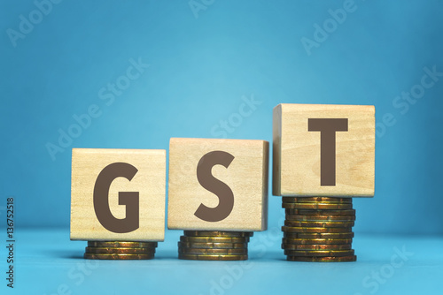 gst concept with wooden blocks and coins on table photo
