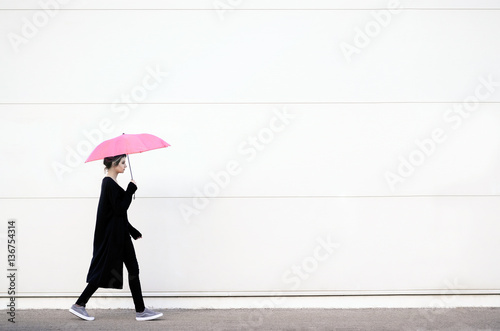 Young woman walking with pink umbrella