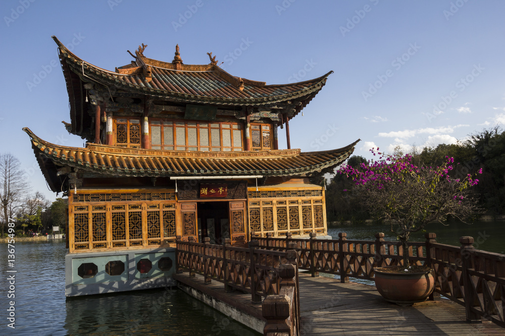 Traditional chinese wooden building with a pier on lake