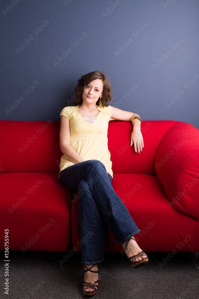 Happy woman sitting in a red chair.