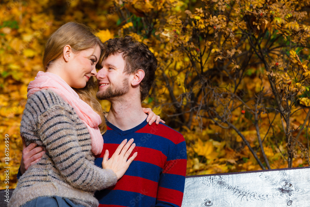 Lovers couple in autumn park on bench