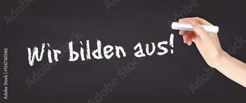 Hand schreibt auf Kreidetafel - wir bilden aus