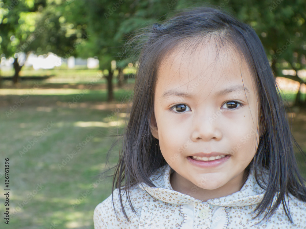 Cute Asian child playing in a park. Cute Asian child playing in a park.
