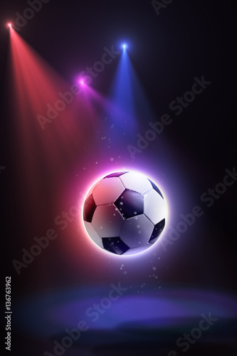 Soccer ball, floating in space and illuminated by the rays on an abstract background