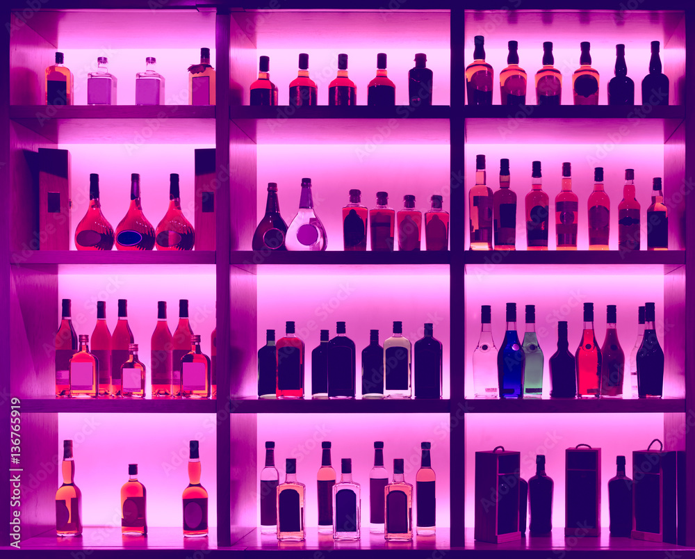 Various alcohol bottles in a bar, back light, logos removed, ton Various alcohol bottles in a bar, back light, logos removed, ton