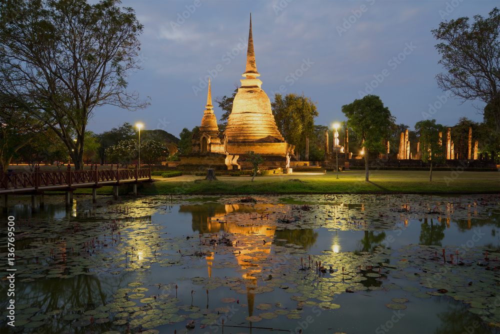 View of ruins of the ancient Buddhist temple of Wat Sa Si in evening twilight. Sukhothai, Thailand