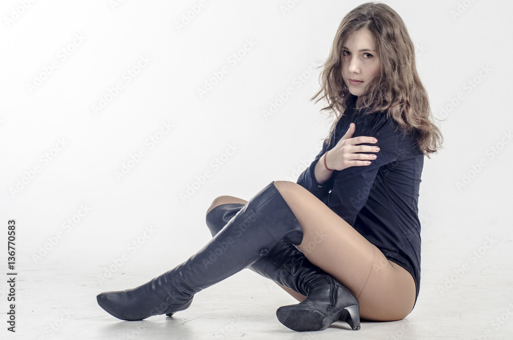 Young girl with curly hair sits gracefully coquettish in a dark shirt and high boots with heels
Young girl with curly hair sits gracefully coquettish in a dark shirt and high boots with heels