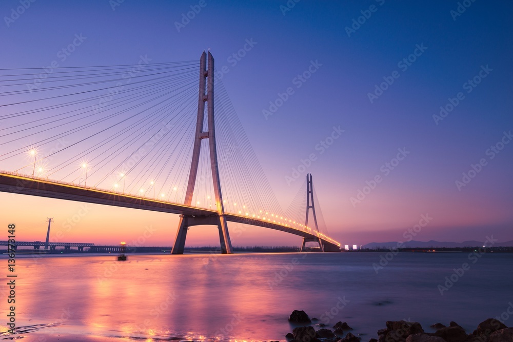 Obraz premium Sunset at The River Spanning Bridge Over The Yangtze River in Nanjing City