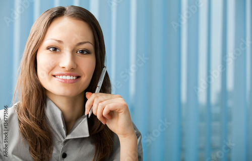 Portrait of beautiful young happy smiling businesswoman with pen