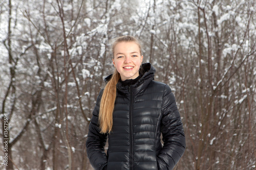 Winter portrait of cute young woman in snow park
