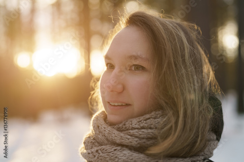 teenage girl portrait in winter pine forest is sunset, shot wide open