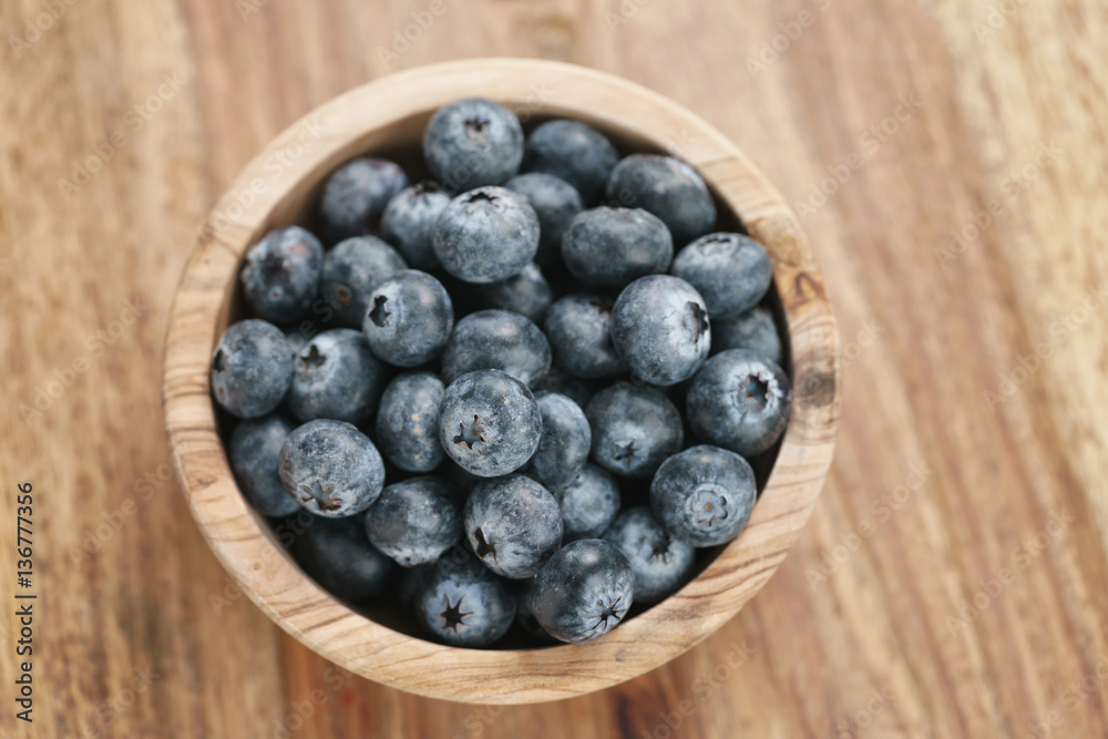 fresh blueberries in wood bowl on table, shallow focus fresh blueberries in wood bowl on table, shallow focus