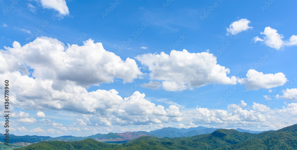 Mountain with cloudy blue sky.