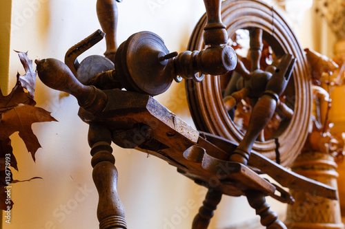 old spinning wheel in the background of wood