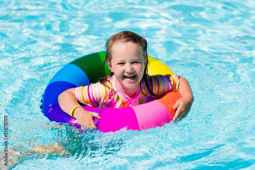 Little girl with toy ring in swimming pool
