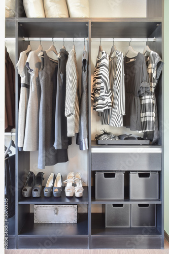 modern closet with row of black dress and shoes in wardrobe.