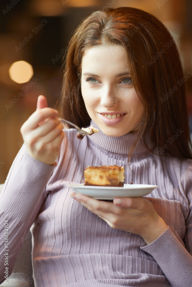 Portrait of young pretty smiling woman eating cake at shopping m Portrait of young pretty smiling woman eating cake at shopping m
