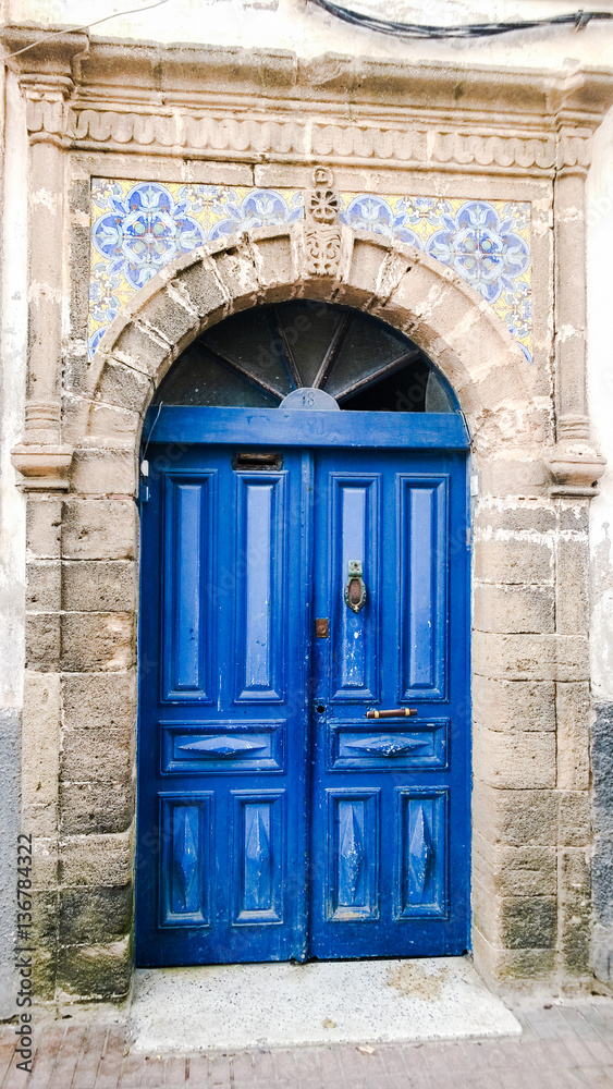 Classy dark blue Moroccan door surrounded with stone, Essaouira,