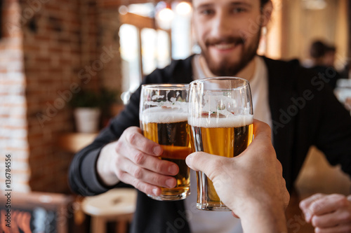 First view of man clinking glasses with friend