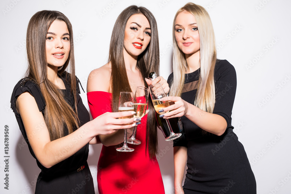 Three young women celebrating and drinking champagne on the party Three young women celebrating and drinking champagne on the party