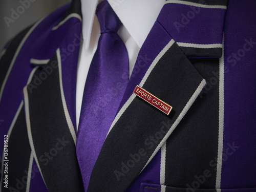 School boys blazer with sports captain red school badge photo