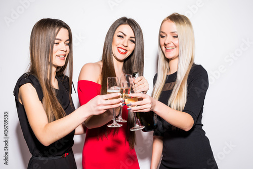 Three young women celebrating and drinking champagne on the party
