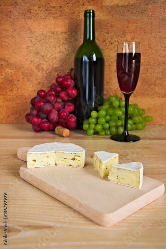 Blue cheese and visible in the background bottle of red wine and glass of wine and grapes
