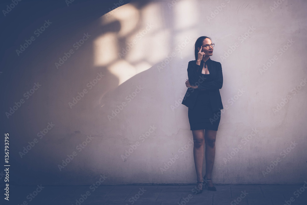 Naklejka premium Business women standing side wall in evening with light and shadow.