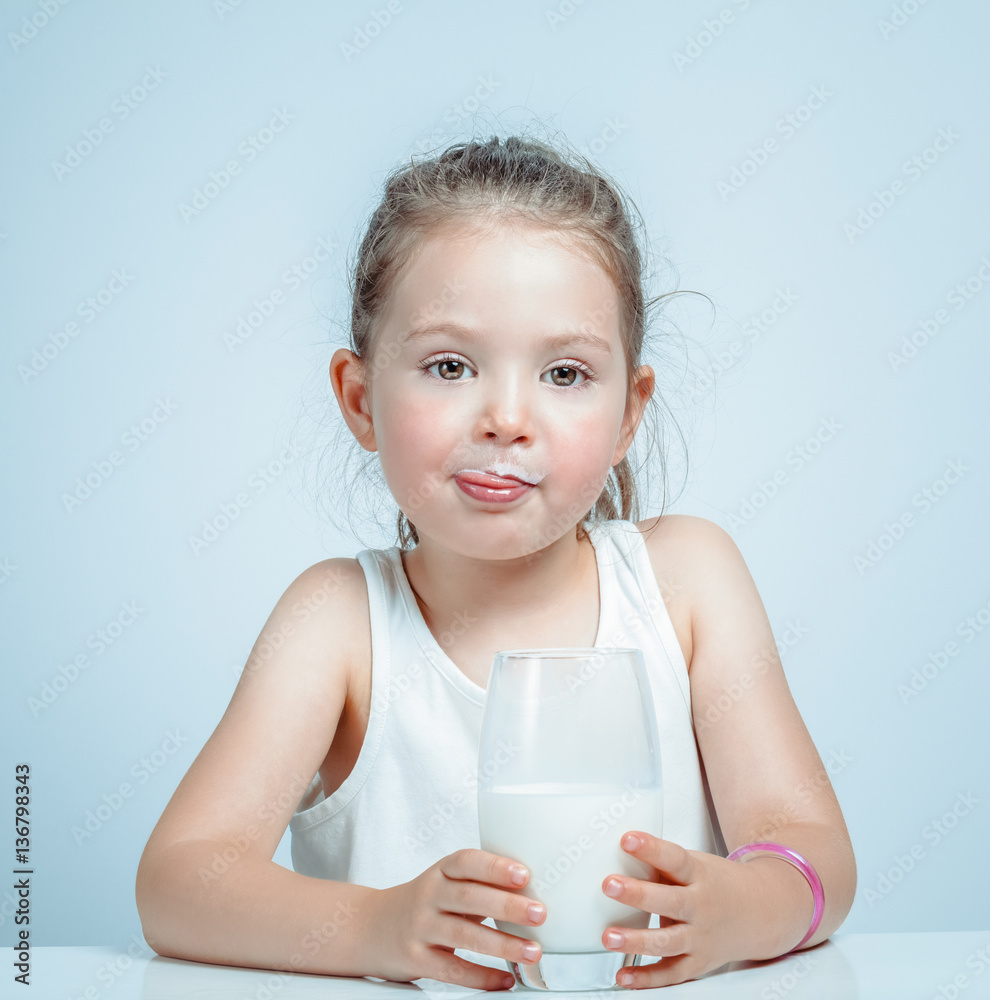beautiful cute little girl drinking milk and licking lips Stock Photo