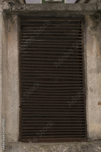 Rusty ventilation shaft in the concrete wall