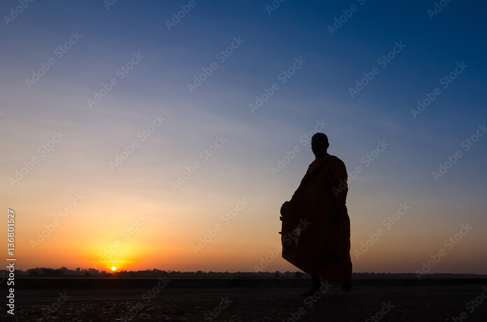 Fototapeta premium Silhouette of monk feet walking on concrete ground for people of