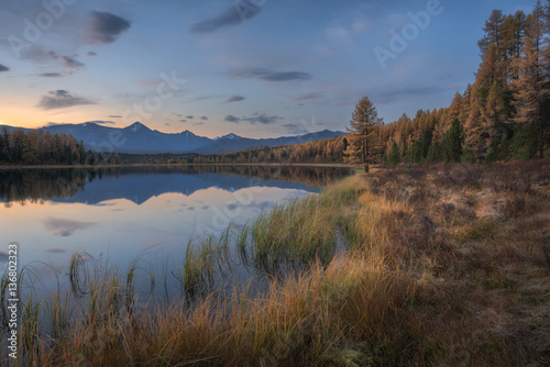 Mirror Surface Lake Autumn Landscape With Mountain Range On Background With Light Pink Sky