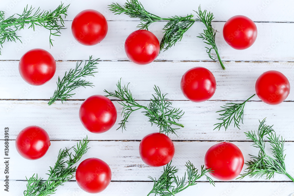 Red tomatoes with fennel branches on a white wooden background Red tomatoes with fennel branches on a white wooden background